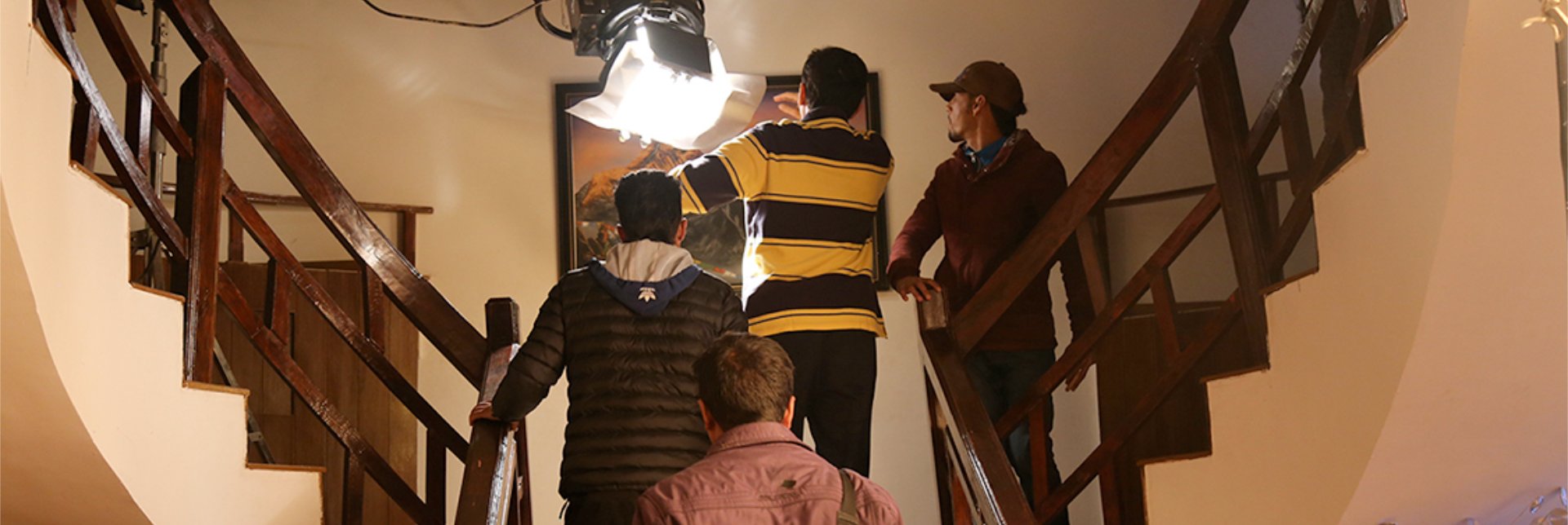 Production crew setting up lighting equipment on a staircase